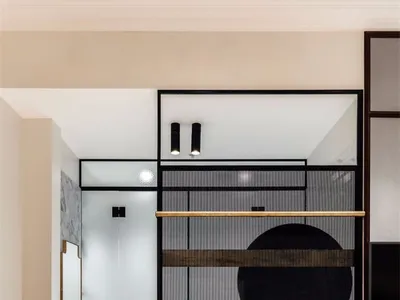 A minimalist bedroom featuring black furniture, glass doors, and a checkered blanket.