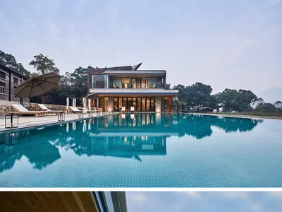 An image of a modern residential building with a large outdoor infinity swimming pool, featuring transparent glass and concre