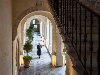 A hotel hallway with stone flooring and brick walls.