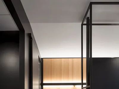 Modern minimalist bedroom with black and white color scheme, wooden accents, and steel furniture.