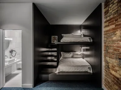 A modern bedroom with industrial elements, featuring concrete walls and a bunk bed design.