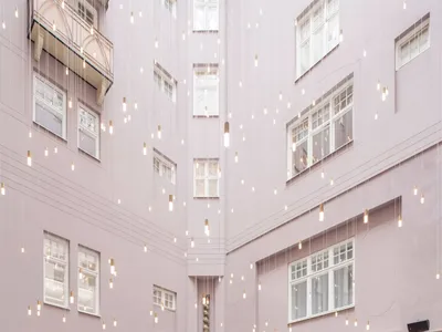 Photo of a modern restaurant interior with textured pink walls and hanging lights.