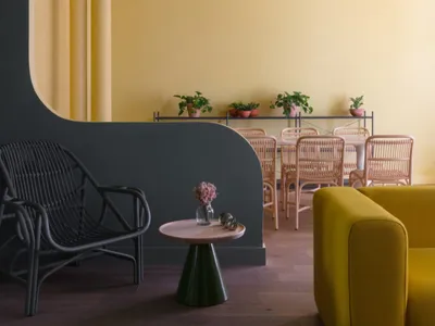 Rattan dining chairs and table in a yellow-themed casual dining room