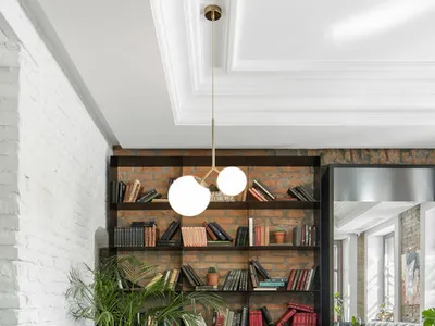 A modern home office with industrial design features, including exposed brick walls and dark wood furniture.