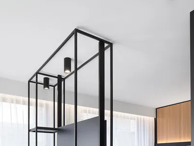 Modern bedroom featuring a minimalist design with black metal frame, glass, and fabric elements.