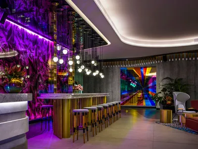A modern bar area featuring metallic finishes and glass elements