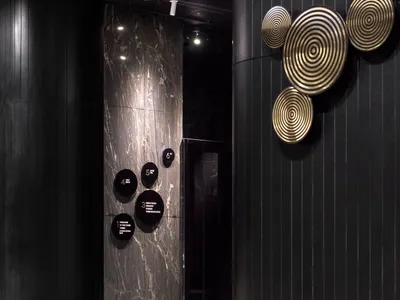 A modern hotel lobby featuring marble and black wood elements.