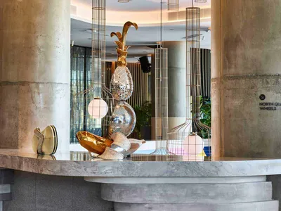 Concrete ceiling lights and decorative elements in a modern hotel reception area.