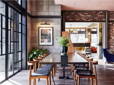 Industrial-style restaurant interior with brick walls, concrete flooring, and wooden furniture.