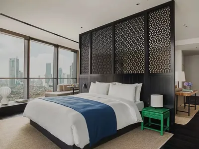 Modern bedroom featuring a glass wall, black headboard, and mixed materials, showcasing contemporary design and comfort.
