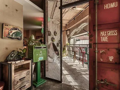 Industrial-style restaurant interior featuring a metal shipping container and rustic elements.