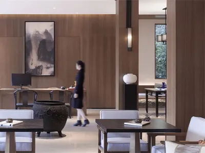 A modern hotel lobby featuring wood materials and minimalist design.