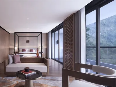 Modern hotel bedroom with wooden furniture and a view of the mountains.
