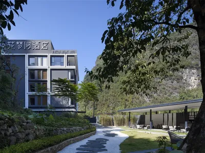 Outdoor view of a modern resort hotel with concrete exterior and greenery.