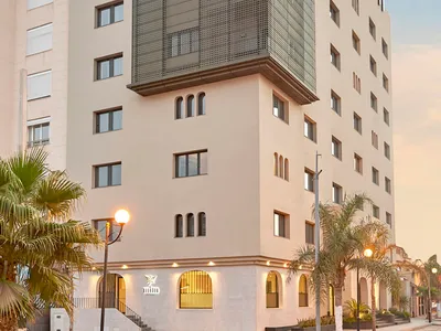 Modern hotel building with concrete and glass exterior.