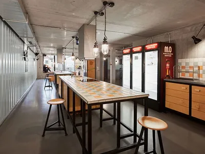 一間工業風格的自助餐廳廚房，採用金屬、木材與瓷磚材質。