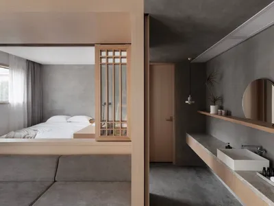 Modern minimalist bedroom with concrete finishes, floating shelves, and a floating bed platform.