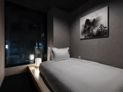 A minimalist bedroom with a textured wall material.