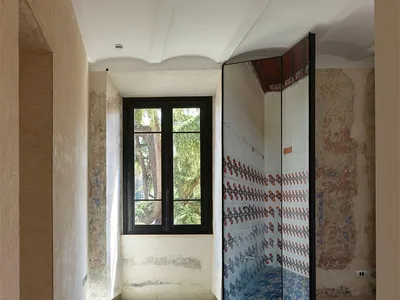 Concrete bathroom renovation with patterned tile floor and mosaic tile wall, featuring a modern shower enclosure.