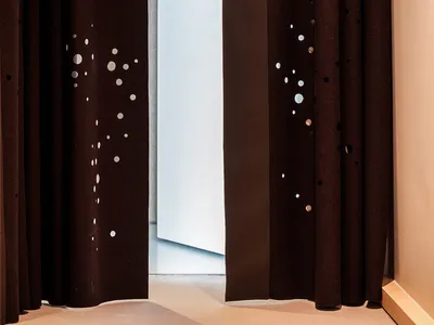 A black curtain with perforations and the number 11 displayed on it, indicating the room number of a hotel.