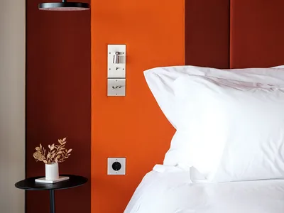 A minimalist bedroom featuring a headboard with fabric upholstery and a sleek, modern design.