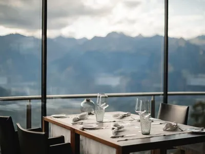 Modern restaurant tablescape featuring glassware and a scenic view through a large window.