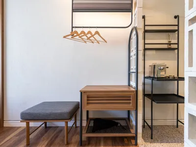 A modern home office featuring wooden furniture, a desk with drawers, and a bench.