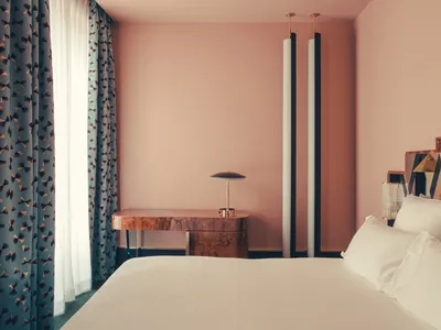 Bedroom with minimalist design, featuring a wooden bed frame and white bedding.