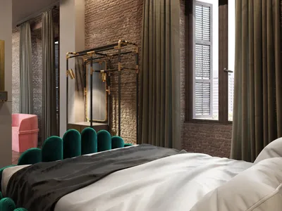 A modern bedroom featuring an emerald green upholstered headboard against a brick accent wall, with a TV stand and a pink arm