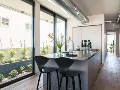 A modern kitchen featuring sleek metallic finishes and minimalistic design.