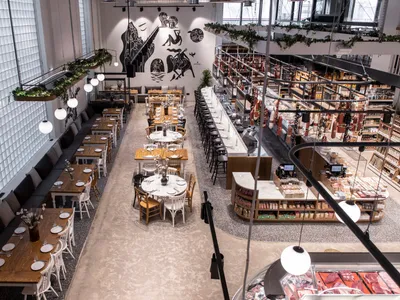 An overhead view of a modern restaurant interior with tables, chairs, and shelves.