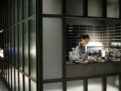 A modern restaurant interior featuring glass walls and stone surfaces.