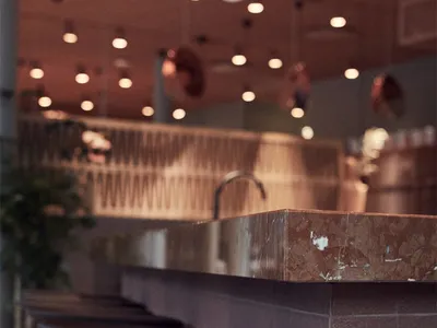 Concrete bar top with industrial lighting and seating.