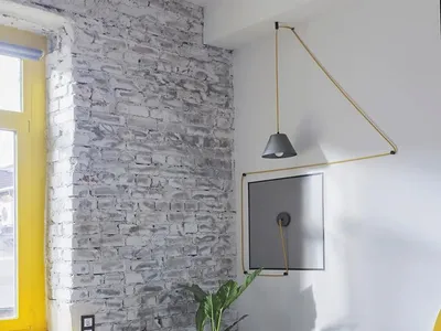 Modern, industrial-styled living room with exposed concrete and brick walls, featuring minimalist furniture.