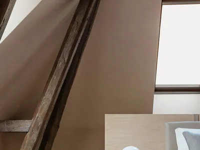 Minimalist bedroom featuring wooden beams and a sleek, modern design.