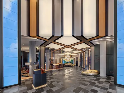 Modern hotel lobby with glass, metal, concrete, and wood elements
