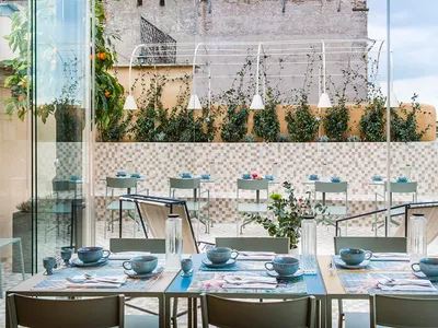 Modern restaurant interior featuring metal, glass, and concrete elements.