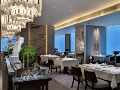 A modern restaurant interior with marble, glass, and stainless steel finishes.