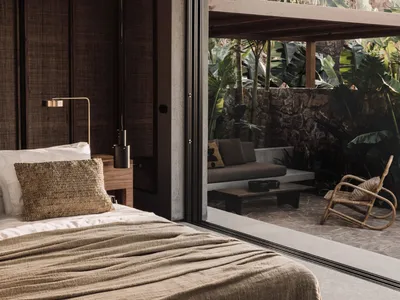 Minimalist bedroom with natural textile accents, showcasing sleek design and cozy elements.