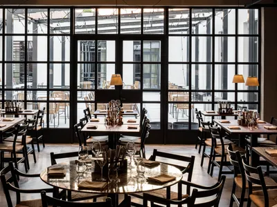 Modern restaurant interior with glass walls and open design layout.