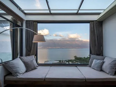 Comfy cushions with sea view, glass windows, and curtains