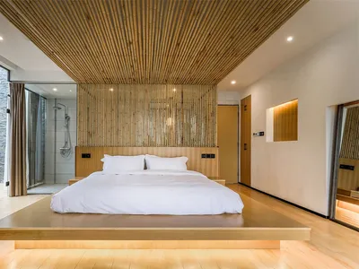 Modern minimalist bedroom featuring bamboo flooring, a platform bed, and a bamboo wall decor.