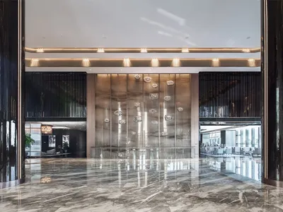 A modern hotel lobby featuring a spacious and elegant marble floor.