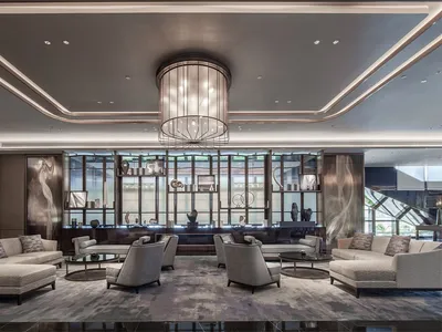 A modern hotel lobby featuring marble, glass, and metal decor.