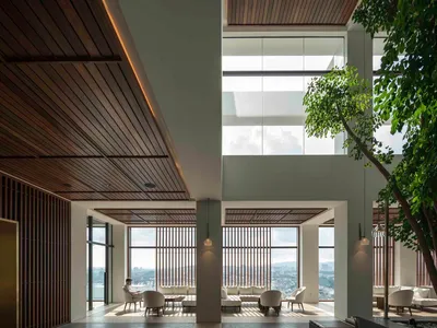 Modern hotel lobby featuring sleek, minimalist design with extensive use of glass and natural light.