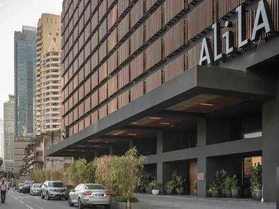 A modern hotel building with a bold, metallic exterior featuring a large sign.
