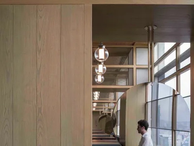 Modern restaurant interior design with wood paneling, glass windows, and metal accents