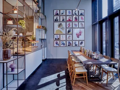 A modern restaurant with a long wooden table and large glass windows