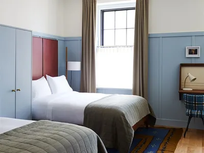 A minimalist bedroom featuring wood, wool, and metal materials and furniture.