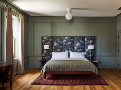 A modern bedroom with a hanging lamp, cozy lighting, and comfortable furnishings.